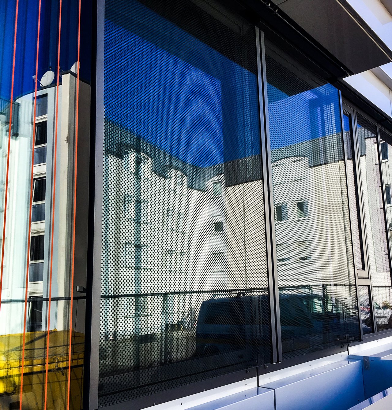 Glasscheibe mit Vogelschutzfolien, links Linienraster orange, rechts Punktraster schwarz.
